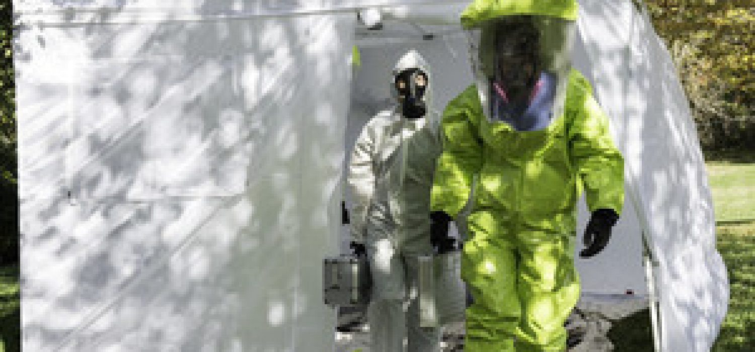 Two healthcare workers depart to the scene dressed in their hazmat gear.