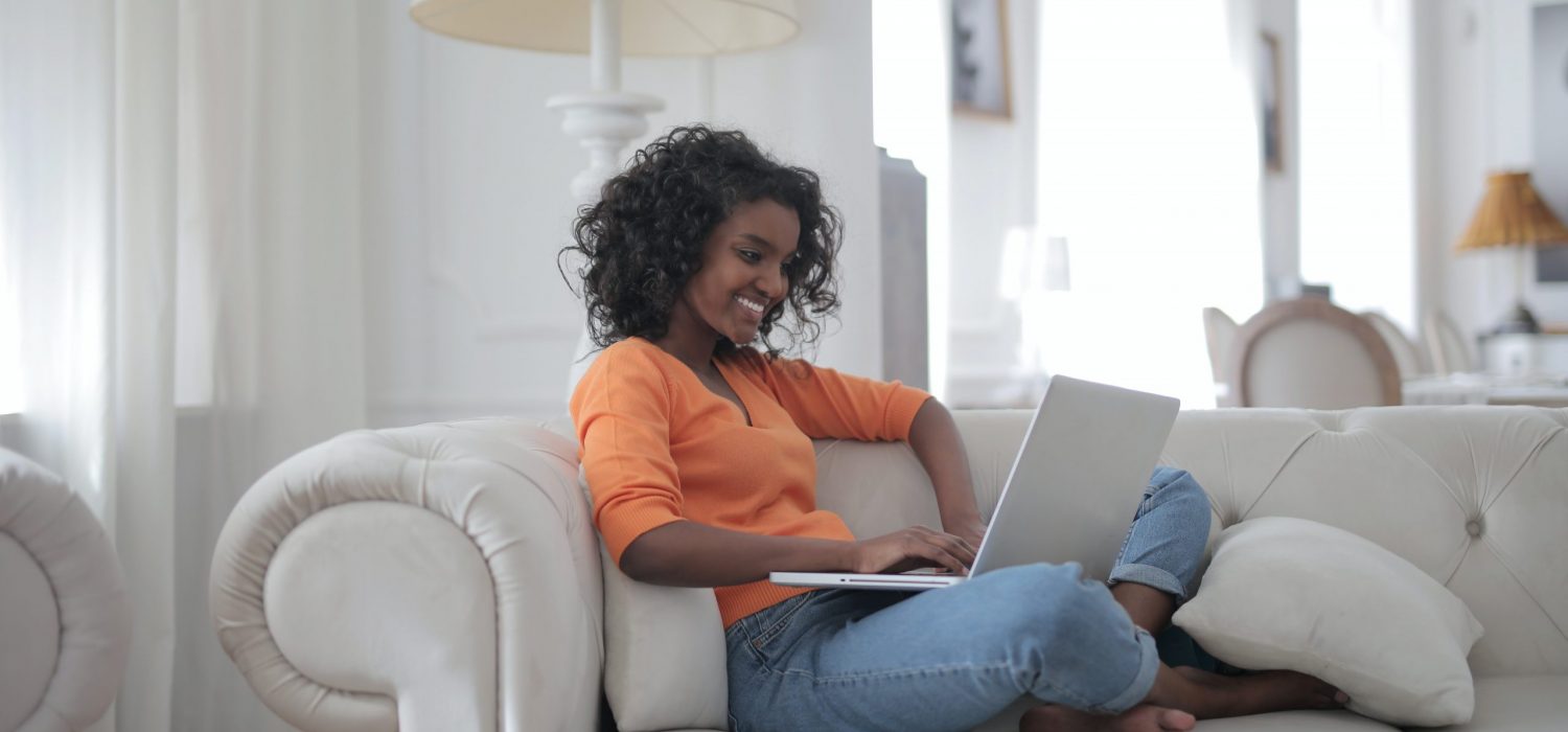 woman-sitting-on-white-couch-using-laptop-computer-3960127