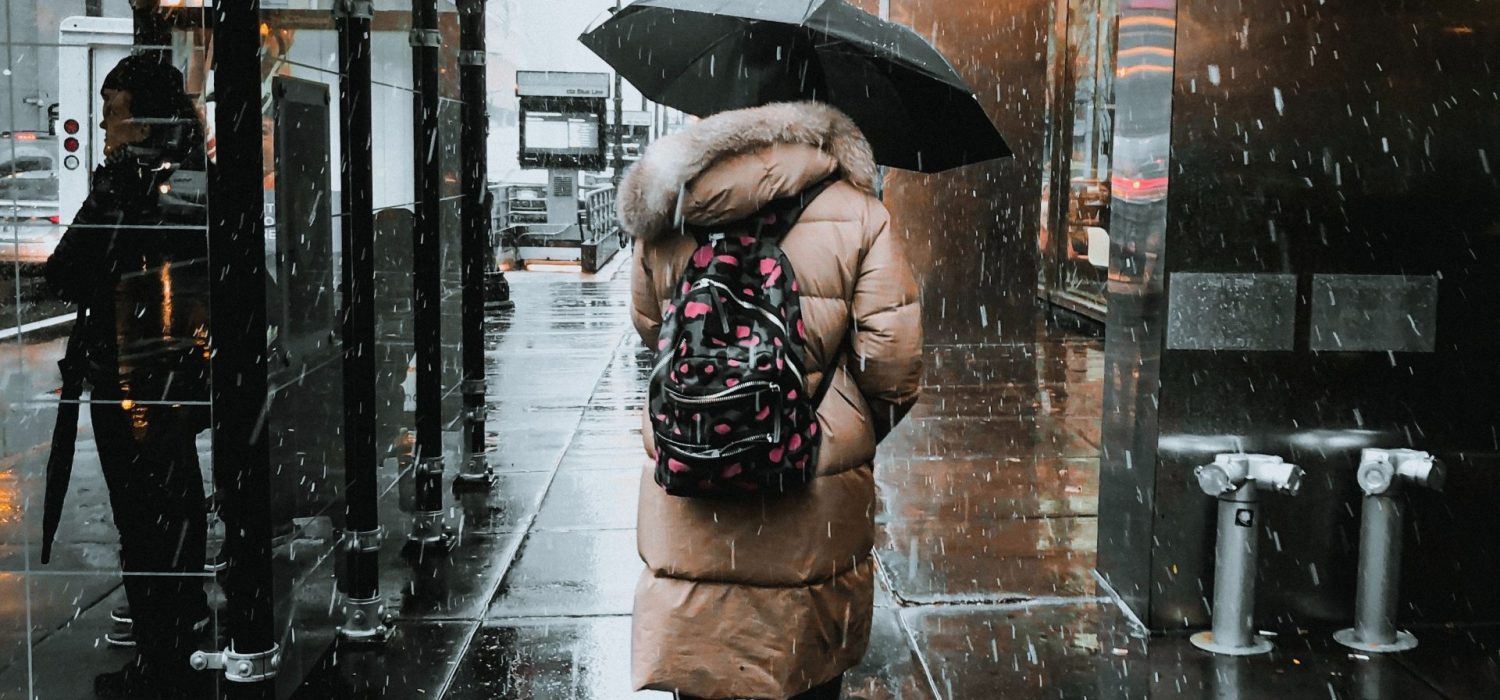 woman-walking-on-street-under-black-umbrella-3240914
